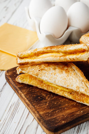 delicious cheese sandwich on a white rustic wooden background.