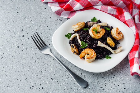 delicious black rice with shrimps and seafood on a gray stone background.の写真素材