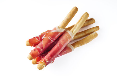 crispy grisini with prosciutto on a white background.の写真素材