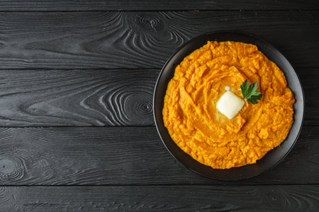 delicious mashed sweet potatoes on a black wooden rustic background.の写真素材