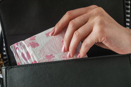 young girl takes out a sanitary napkin from her handbag, hygiene concept.