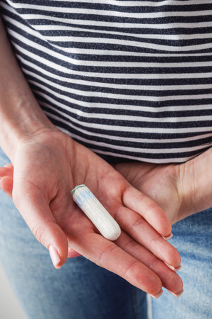 young girl holding a hygienic menstrual tampon hygiene concept.