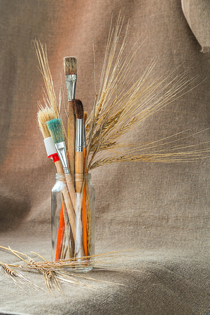 Paintbrushes with ears of cereal in a glass jarの写真素材