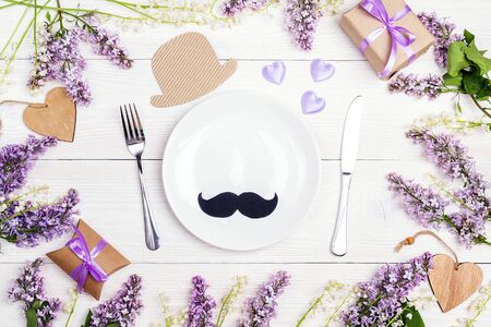 Father's Day table setting with cutlery and spring flowers on white wooden table. Top view.の写真素材