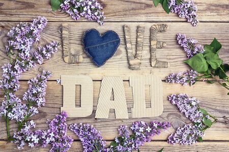 Fathers day background with cardboard message and lilac flowers on old wooden table. Happy fathers day concept.の写真素材