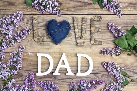 Fathers day background with cardboard message and lilac flowers on old wooden table. Happy fathers day concept.の写真素材