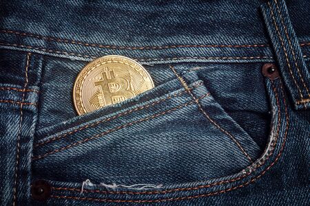 Bitcoin coin in a jeans pocket. Digital currency. Cryptocurrency. Golden shiny coin with bitcoin symbol. Virtual money concept.の写真素材