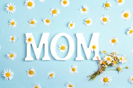 Mothers day background with letters and chamomile flowers on blue background. Happy mother's day concept.の写真素材
