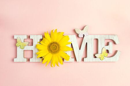 Decorative word Home with butterflies and sunflower on pink background. Copy space. Home sweet home.の写真素材