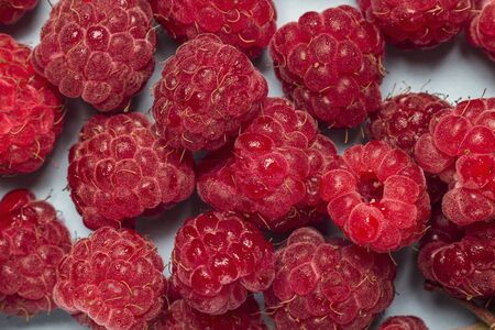 Close-up fresh raspberries on blue background. Top view.