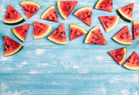 Sliced watermelon on blue wooden background with copy space. Flat lay, top view.
