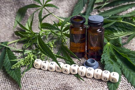 Bottle with hemp oil and cannabis leaves on burlap. Medical cannabis concept.の写真素材