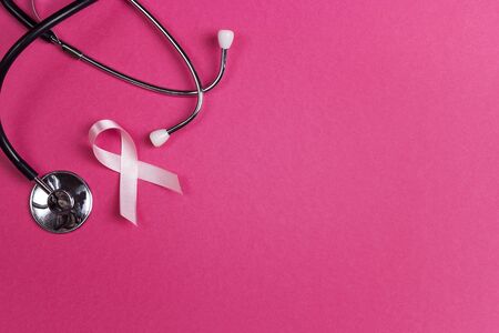 Pink ribbon and stethoscope on pink background with copy space. Breast cancer awareness symbol. October awareness month campaign.の写真素材