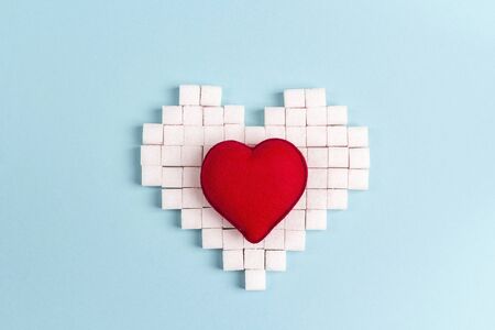 Heart from sugar cubes with red decorative heart on a blue background.の写真素材