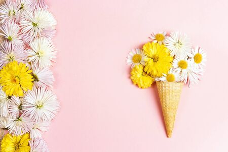 Waffle cone with flowers on pink background. Flat lay, copy space, top view.の写真素材
