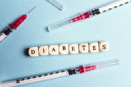 Insulin syringe and the word Diabetes on a blue background. World Diabetes Day, 14 November. Diabetes concept.の写真素材