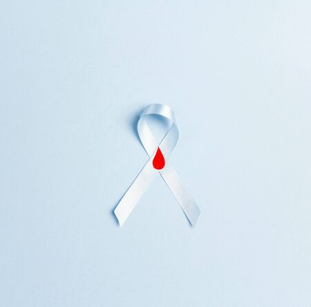 Blue ribbon awareness as symbol of diabetes Type 1 on a blue background. World diabetes day concept.の写真素材