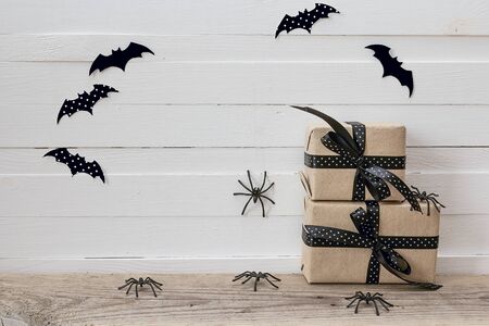 Halloween background with gifts boxes, decorative spiders and bats on white boards. Space for text.の写真素材