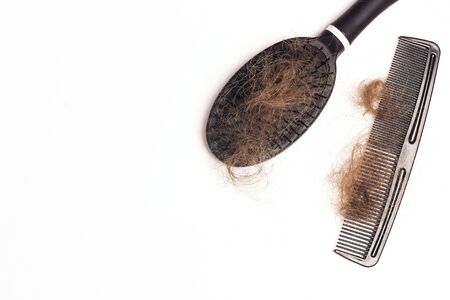 Comb and brush hair with hair loss on white background. Copy space. Beauty, dermatology and health...