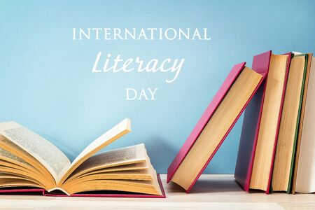 International Literacy Day concept with stack of books with open book on a blue background.の写真素材