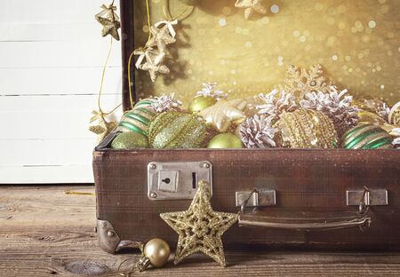 Christmas decorations in an old vintage suitcase on wooden boards. Space for text. Top view.の写真素材