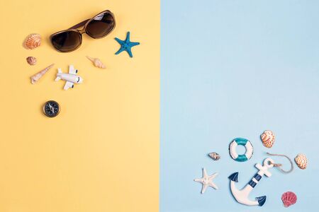 Flat lay travel concept with vacation accessories and symbols on a yellow and blue background. World...