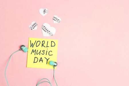 International Music Day background with turquoise earphones and music hearts on pink background. Top view, flat lay.の写真素材