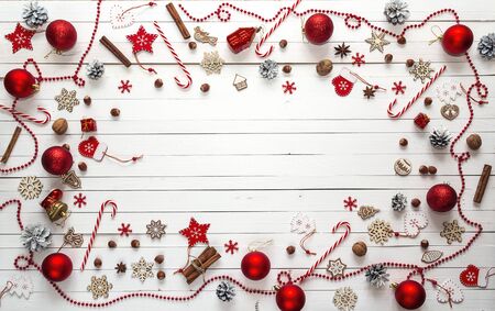 Christmas background with red decorations, sweets and space for text on white wooden boards.Top...