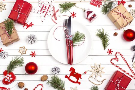 Festive table setting with cutlery and Christmas decorations on white wooden table. Top view. Christmas tableware.の写真素材