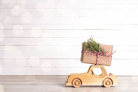 Gift box on wooden toy car. Christmas holiday celebration concept. Copy space.の写真素材