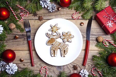 Festive table setting with cutlery and Christmas homemade gingerbread cookies on wooden table. Top view. Christmas tableware.の写真素材