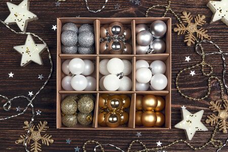 Box with a set of Christmas balls on a wooden table. Top-down composition.の写真素材