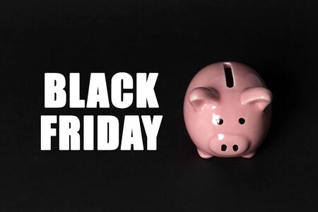 Black friday sale concept with piggy bank on black background. Shopping sale concept.の写真素材