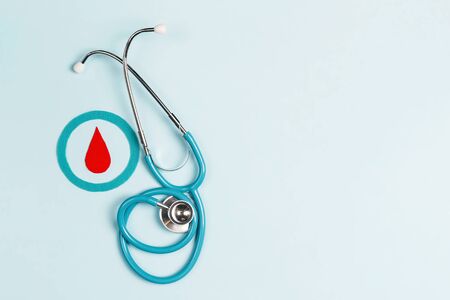 Blue circle with a drop of blood as a symbol of diabetes with stethoscope on a blue background. World diabetes day concept, 14 november.の写真素材