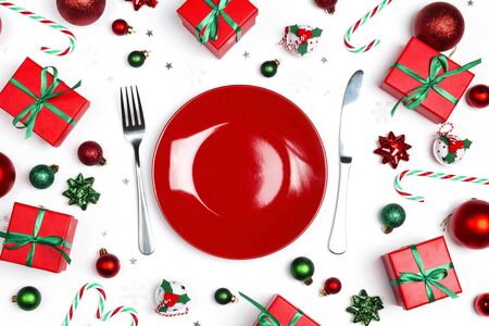 Christmas festive table setting with cutlery, gifts and decorations on white table. Top view.