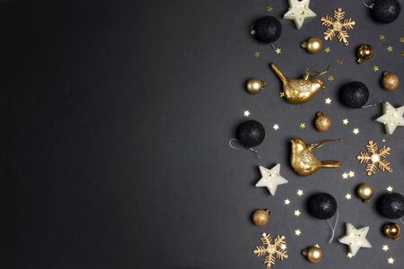 Golden Christmas decorations on back background with copy space for text. Composition of birds, candles stars, snowflakes and balls. Top view, flat lay.の写真素材