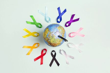 The globe with circle of  colorful awareness ribbons on blue background. World cancer day concept, February 4. Healthcare and medicine concept. の写真素材