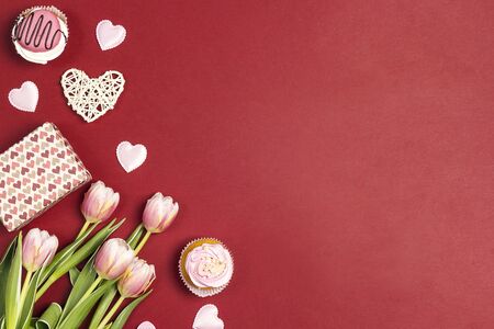Romantic love background with tasty cupcakes and pink tulips. St. Valentine, Mothers, Womens Day concept. Copy space, overhead shot. の写真素材