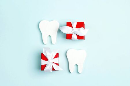 Teeth and gift boxes on a blue background. Happy Dentist's Day concept.の写真素材