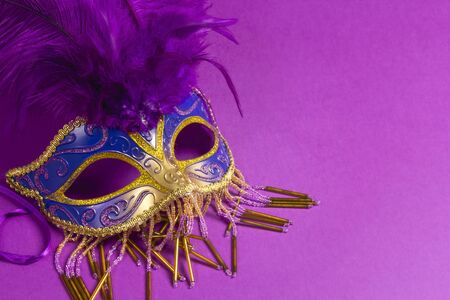 Carnivale mask with purple feathers on a purple background with copy space.の写真素材