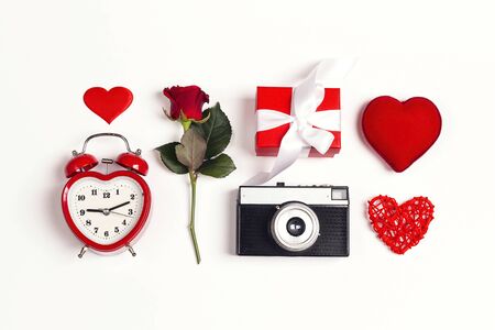 Romantic top down composition of the alarm clock, rose, vintage camera, gift and hearts on white background.  St. Valentines Day concept. の写真素材