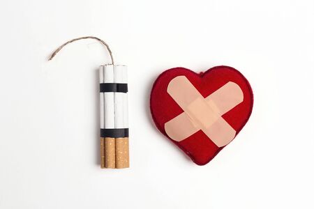 Dynamite made from cigarettes with heart with a band-aid on white background. Stop smoking concept.の写真素材