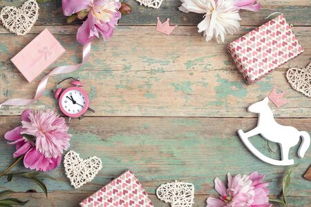 Festive frame of  pink peonies, gifts and hearts on an old turquoise background with shabby paint. Little girl birthday concept. Place for text, top down composition.の写真素材