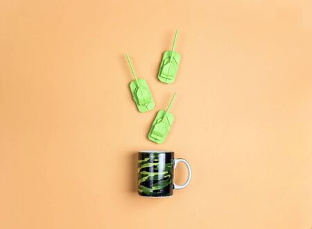 Camouflage mug with origami paper tanks on yellow  background. Top down composition. Defender of the...
