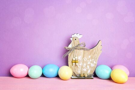 Colored Easter eggs with decorative hen on purple background. Space for text. 