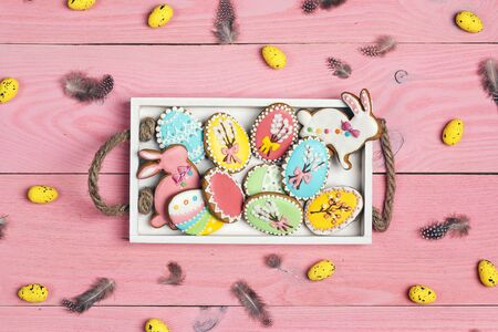 Easter homemade gingerbread cookies in  tray on a pink wooden background. Gingerbread in shape of...