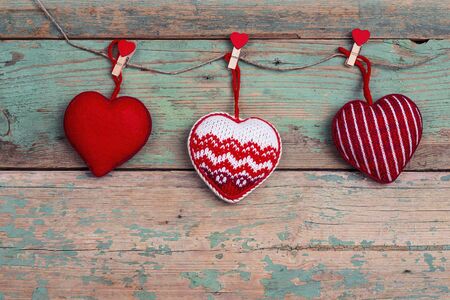 Hanging hearts on old turquoise wooden background. Space for text. Valentine's day concept.Top view.
