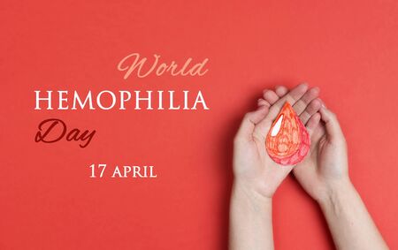 Female hands hold a drop of blood on a red background. World Hemophilia  Day background. Hemophilia awareness poster.の写真素材