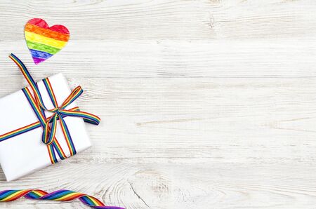 Gift box with rainbow LGBT ribbon on a light wooden background. Homosexual and lgbt concept.の写真素材