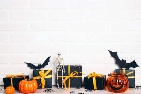 Halloween holiday background with gifts and decorations against a white brick wall. Copy space for text.の写真素材